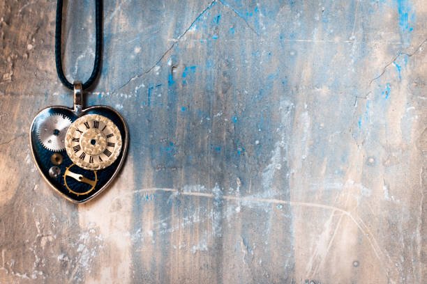 on the old ancient wall there is a pendant in the shape of a heart on a rope, and inside it is an old clock mechanism; concept photo show that eternal love is timeless